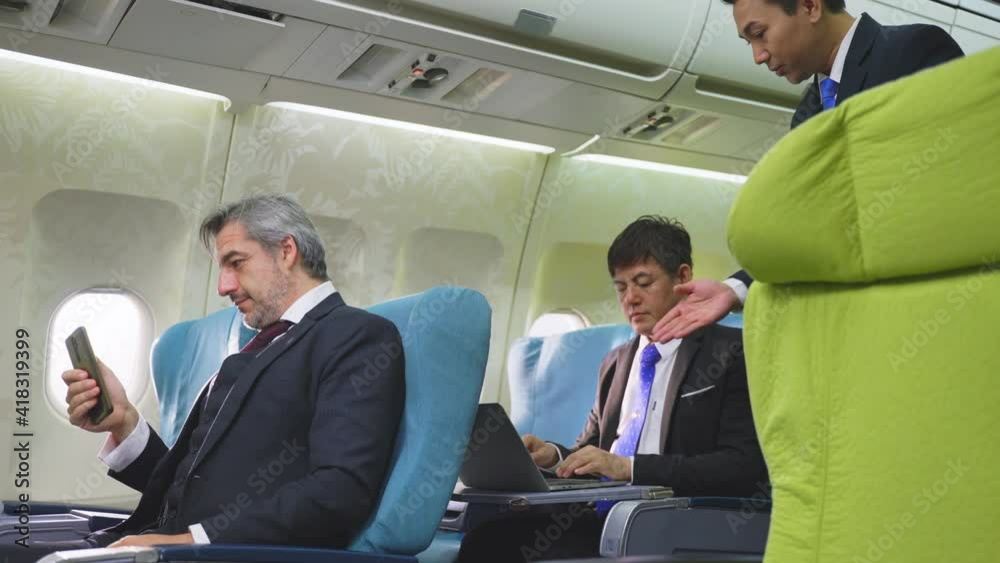 Asian steward informing passengers to turn off electronic devices. Asian steward informing passengers to turn off electronic devices.