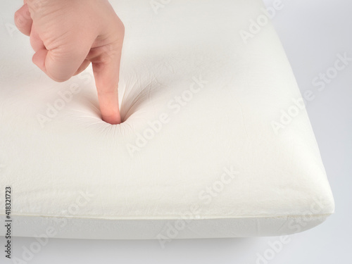 Orthopedic pillow, memory foam. Handprint on the pillow. Comfortable bedding with orthopaedic, therapeutic effect. Memory foam material.