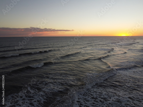 sunset in the atlantic ocean coast of argentina monte hermoso. waves with foam and beautiful sky colors