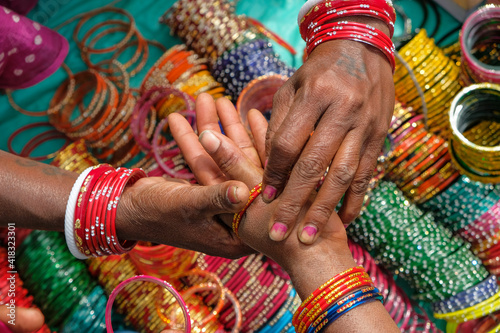 Kunduli, India - February 2021: Adivasi woman from the Kondh tribe buying bracelets in the Kunduli market on February 19, 2021 in Odisha, India.