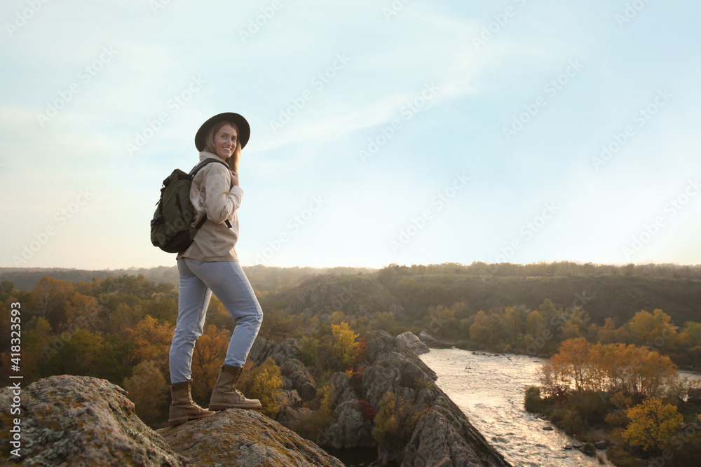 Woman with backpack enjoying beautiful view near mountain river