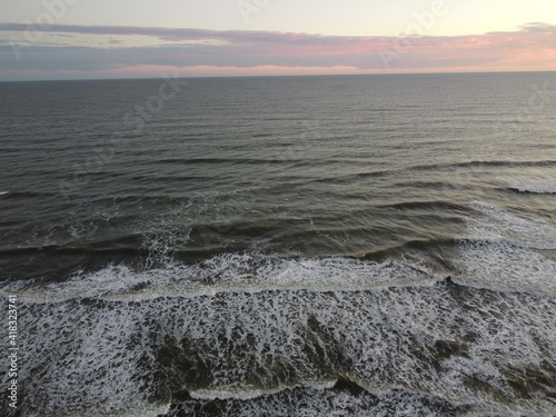 sunset in the atlantic ocean coast of argentina. waves with foam and beautiful sky colors © nehuen