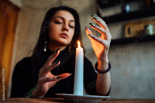 the girl is guessing on a lighted candle and cards, predicting the future and fate