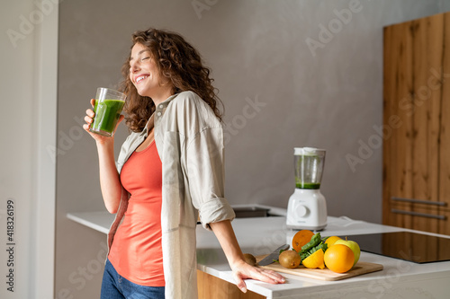 Woman drinking detox drink at home photo