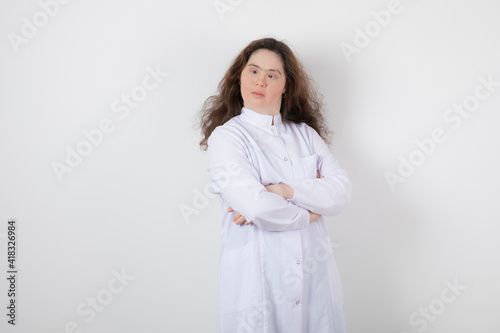 Portrait of a young girl with down syndrome standing with crossed arms