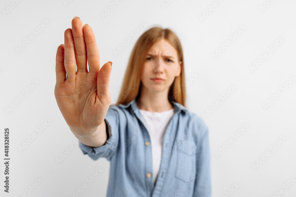 woman standing with outstretched hand showing stop gesture on white background woman standing with outstretched hand showing stop gesture on white background