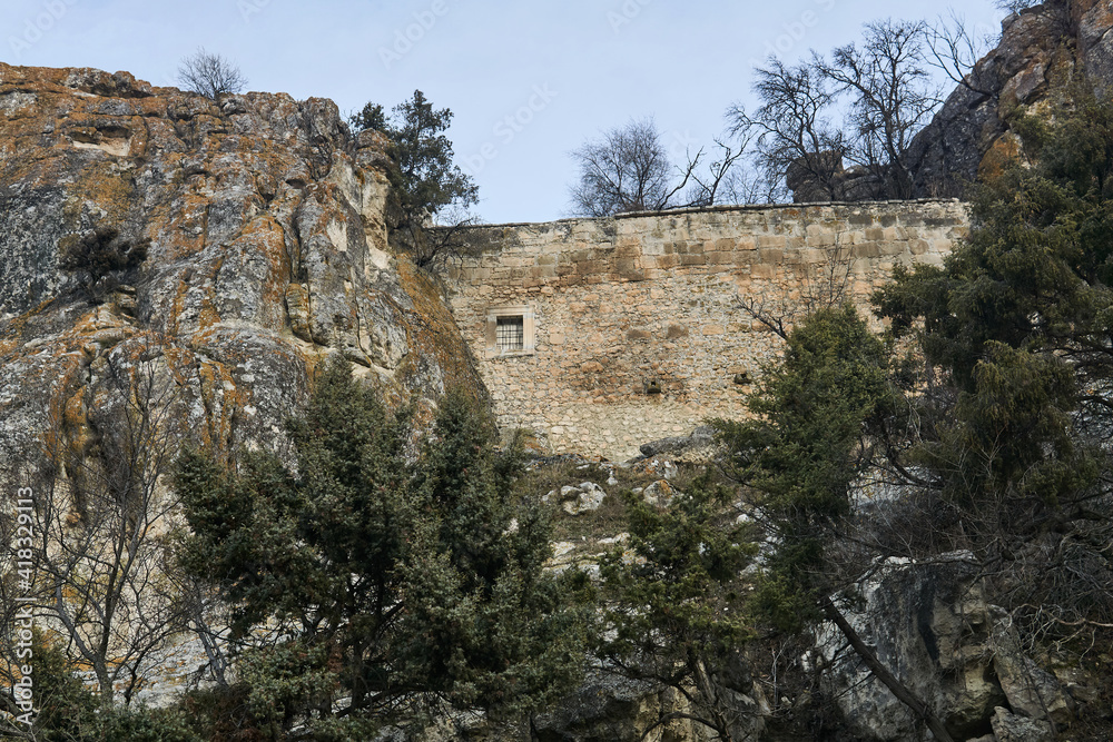 view of the ruins of an ancient ancient fortress wall between the rocks