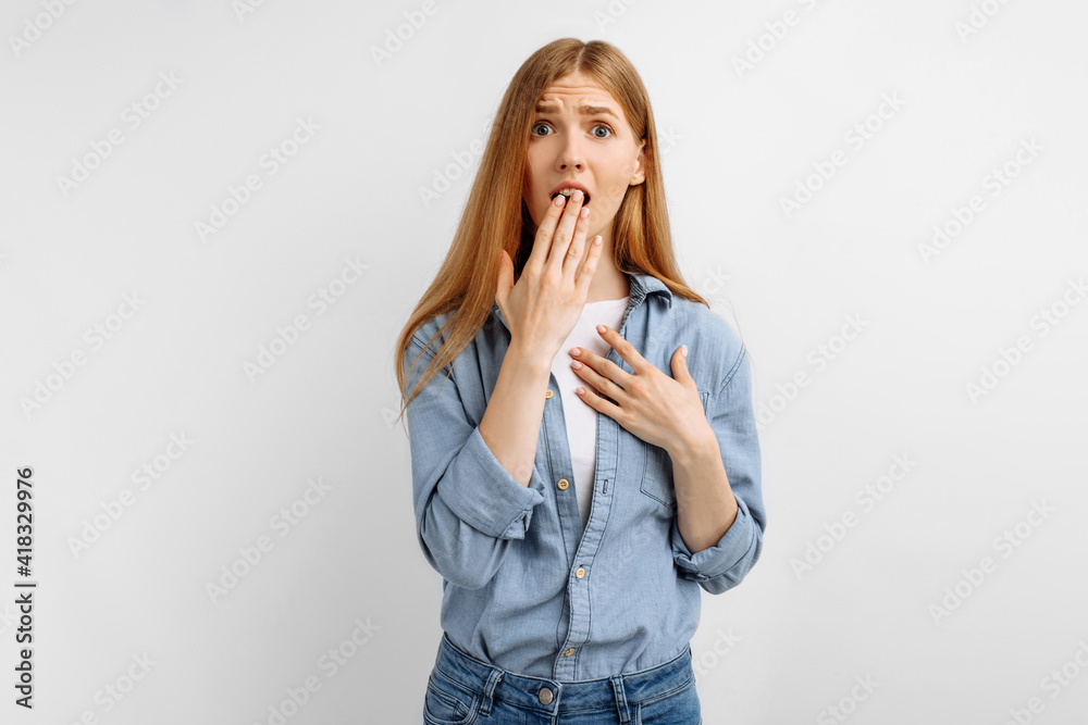Young woman, shocked, covering her mouth with hands, on white background Young woman, shocked, covering her mouth with hands, on white background