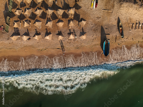 Aerial view of amazing beach with umbrellas and turquoise sea at sunrise. Black Sea at Vama Veche, Romania photo