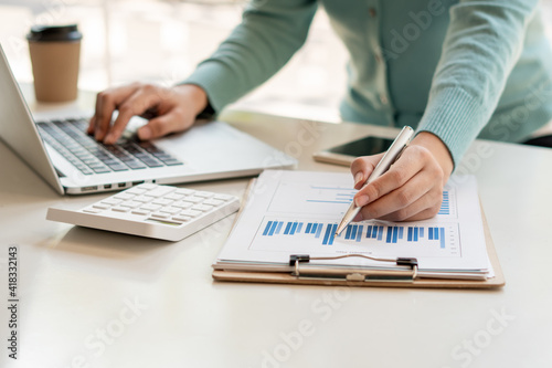 Businessman is inspecting the business reports graphs to audit the financial reports. Analyzing the revenue and auditing the budget concept.