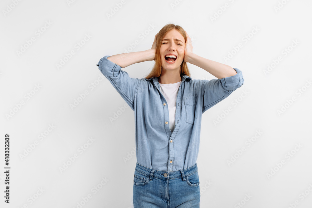 dissatisfied aggressive woman covering ears with palms on white background