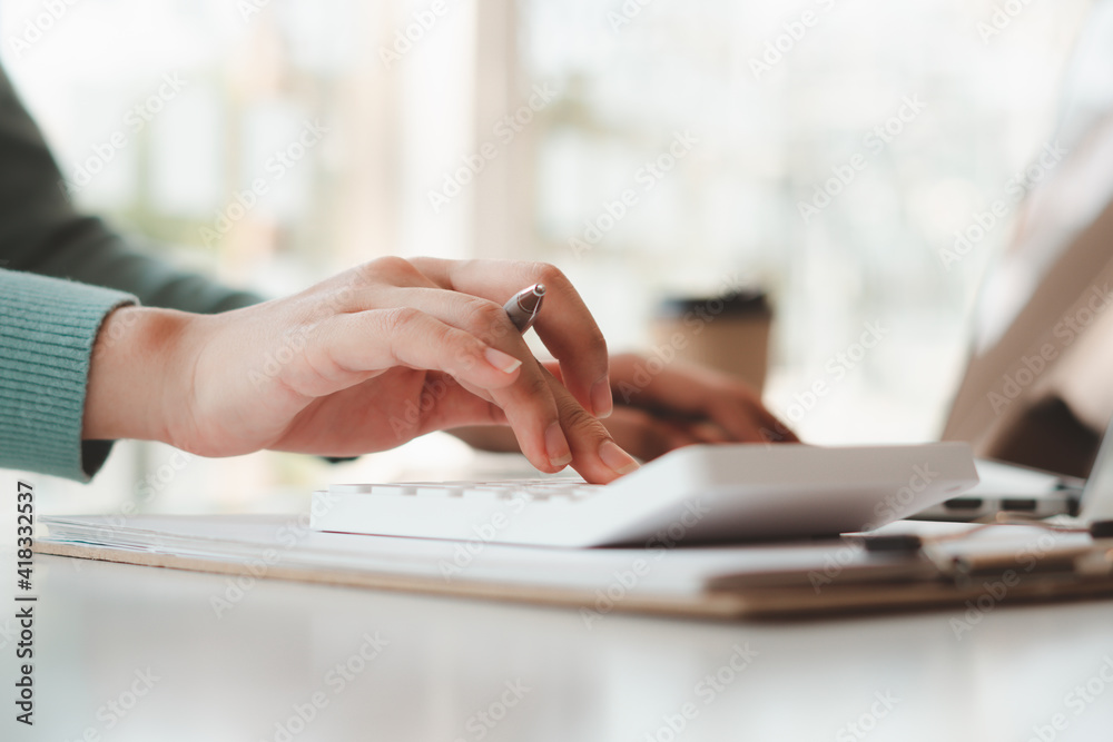 businessman or accountant hand working on calculator to calculate business data, accounting document and laptop computer at office, business concept businessman or accountant hand working on calculator to calculate business data, accounting document and laptop computer at office, business concept