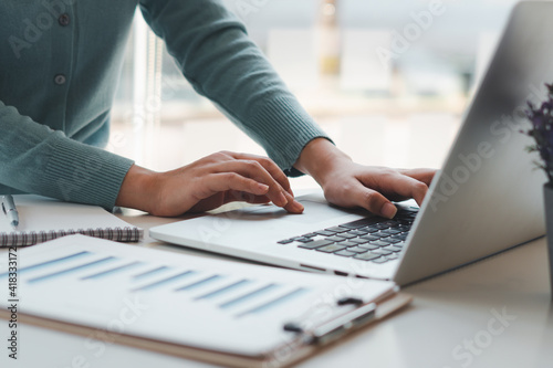 Business woman working and typing on laptop computer on the table.