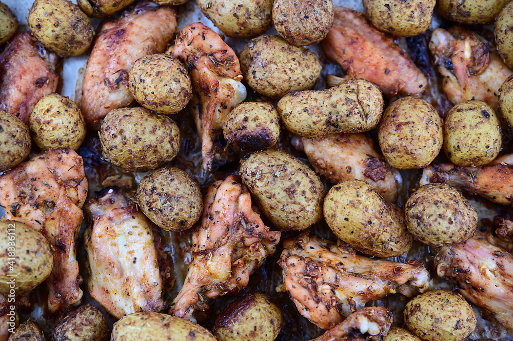 Baked potatoes in spices with chicken wings. Baked potatoes in spices with chicken wings.