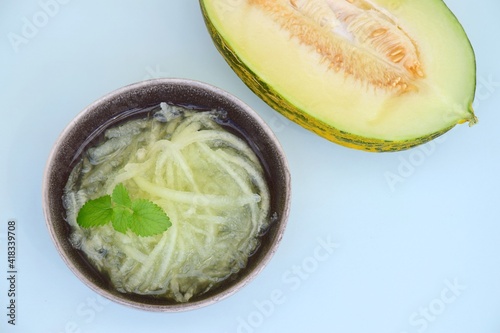 Es Blewah. Indonesian cold fruity drink of melon strips garnish with mint leaf photo