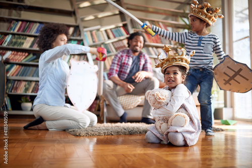 Mom and her son yelling and playing with swords at home while having a good time with the family. Family, together, love, playtime