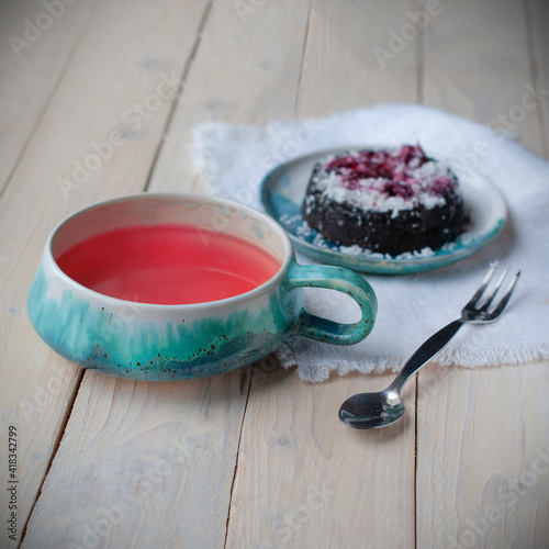 Creative layout made of cup of herbal tea on a wooden background and cupcake. Top view.