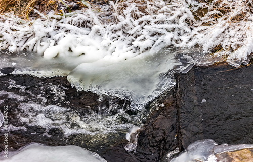 Fast river with ice and snow in late autumn