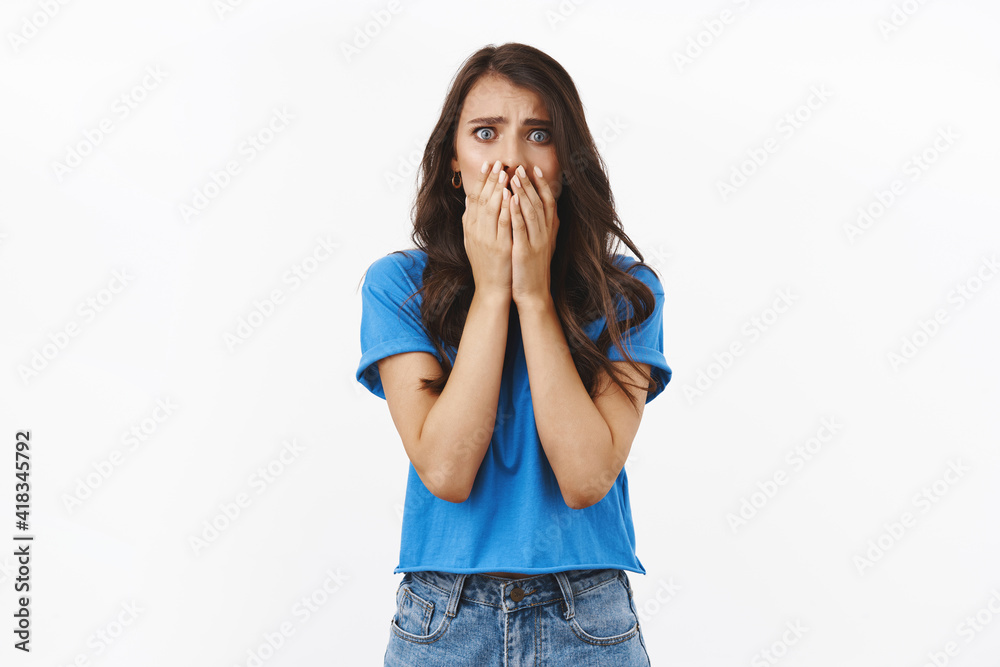 Accident, trouble, bad situations. Shocked and concerned young woman in panic, saying oh gosh, covering mouth witness terrible crime, standing scared and useless over white background Accident, trouble, bad situations. Shocked and concerned young woman in panic, saying oh gosh, covering mouth witness terrible crime, standing scared and useless over white background
