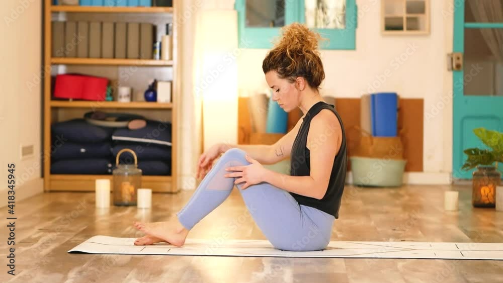 Calm female doing yoga in Navasana exercise Calm female doing yoga in Navasana exercise