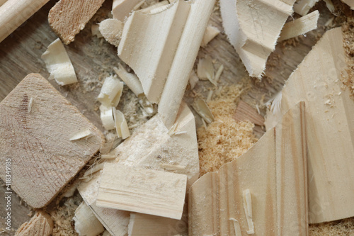 A dumped pieces of wood with sawdust crumbs lie on the floor. photo