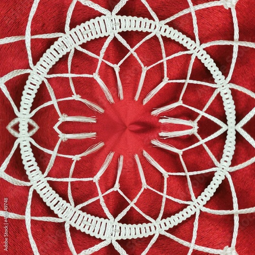 patterns and radial hexagonal designs from traditional plain dark red material with white tassel fringe  © john