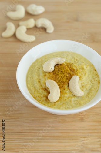 Curry cashew sauce on wooden background 
