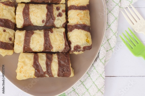 Dadar Gulung or Rolled pancakes are a typical Indonesian and Malaysian food which can be classified as a pancake filled with grated coconut mixed with liquid Javanese sugar. Flat lay 