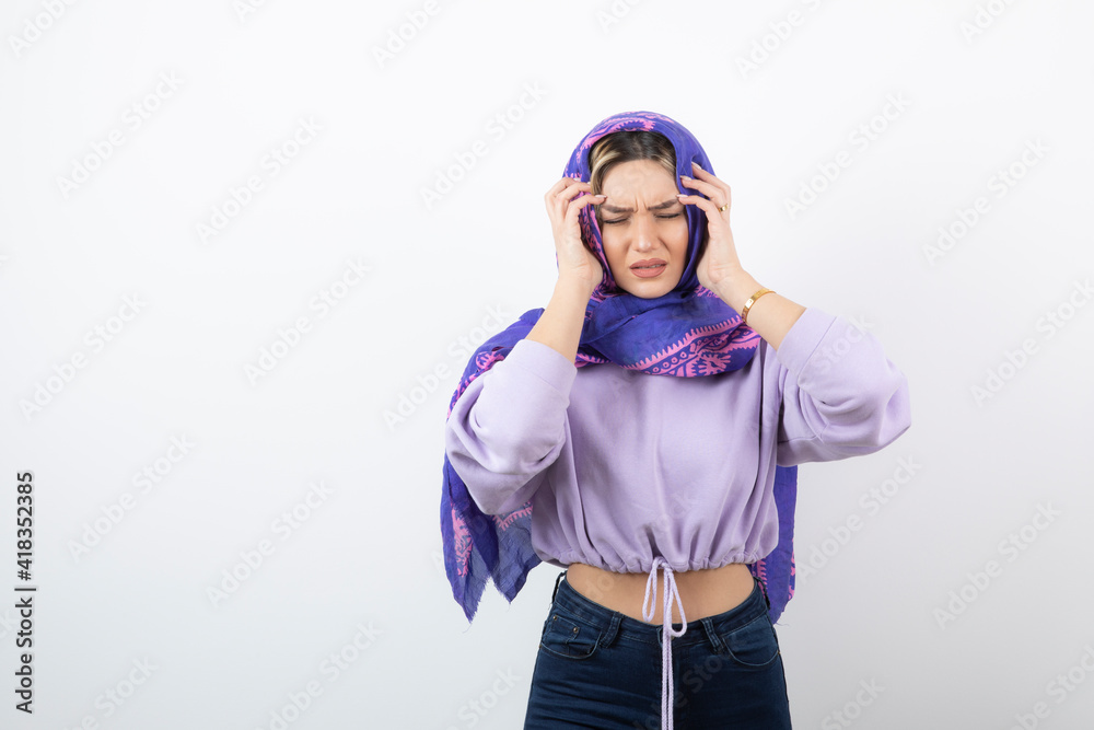 Portrait photo of a young pretty woman model standing and holding head Portrait photo of a young pretty woman model standing and holding head