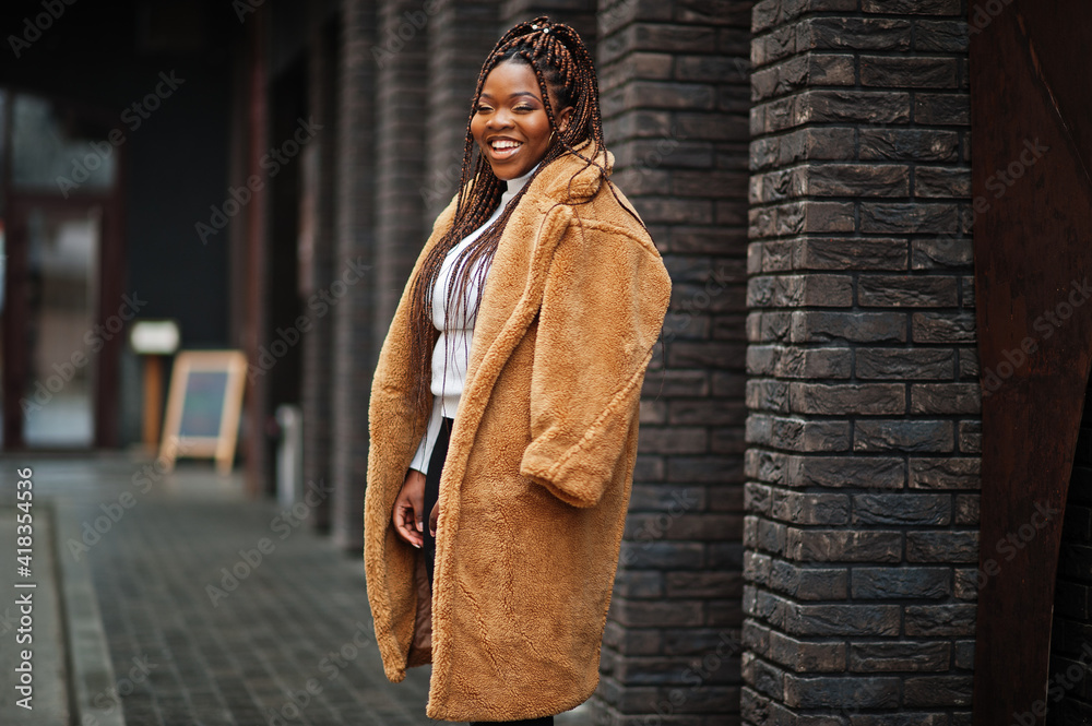 Naklejka premium Glamorous african american woman in warm fur coat pose at street.
