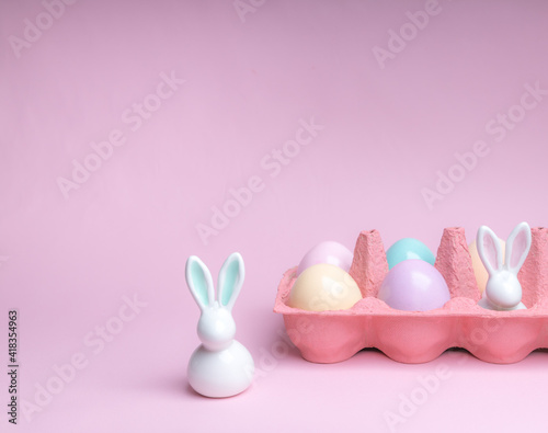 Easter colorful photografie with eggs group and bunny egg on pink background, copy space 