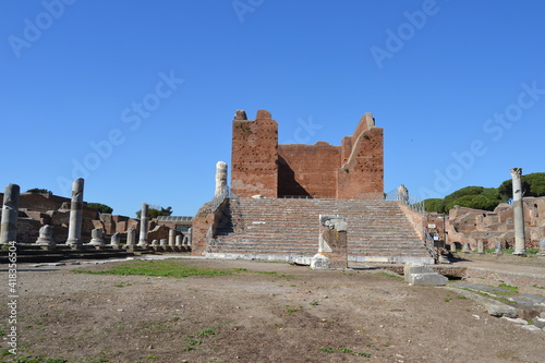 Capitolium in Ostia Antica ancient Roman temple ruin with stairs and brick walls empty on a sunny day 