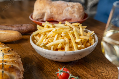 Fried french potatoes. Enjoying tasty vegan food with friends in restaurant. Selective focus