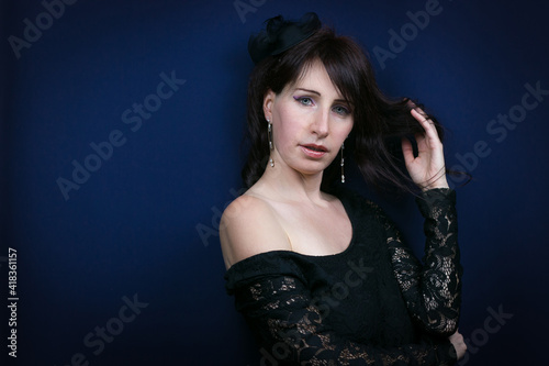 Studio shot of dark woman with ice eyes isolated on blue