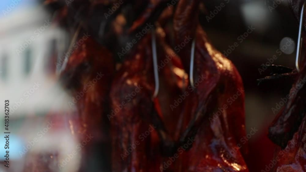 Close-up slow motion shot of meat hanging from hooks seen through glass - San Francisco, California