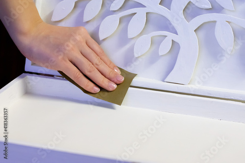Craftwork white painted wooden casket polishing. DIY box