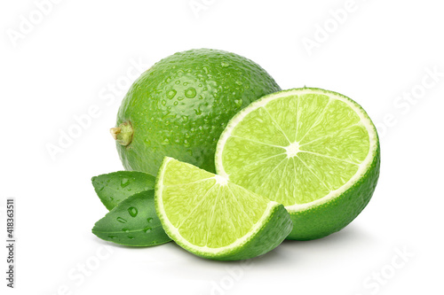 Fototapeta Green lime with cut in half and slices isolated on white background