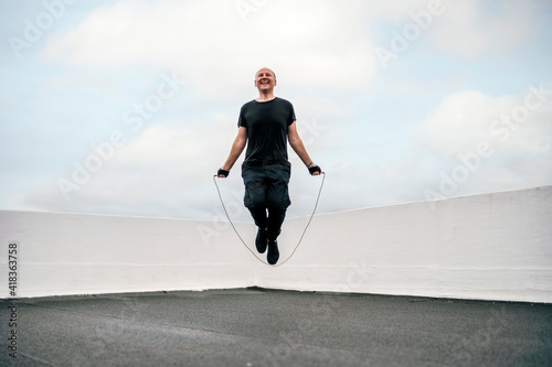 A man exercising on the rooftop using jumping rope during the lockdown