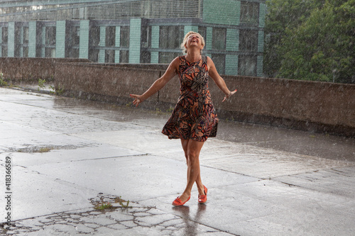 Attractive caucasian female dancing under the summer rain