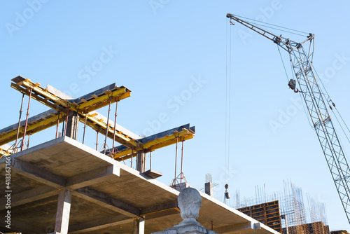 Construction work and crane. Concrete and steel structures.