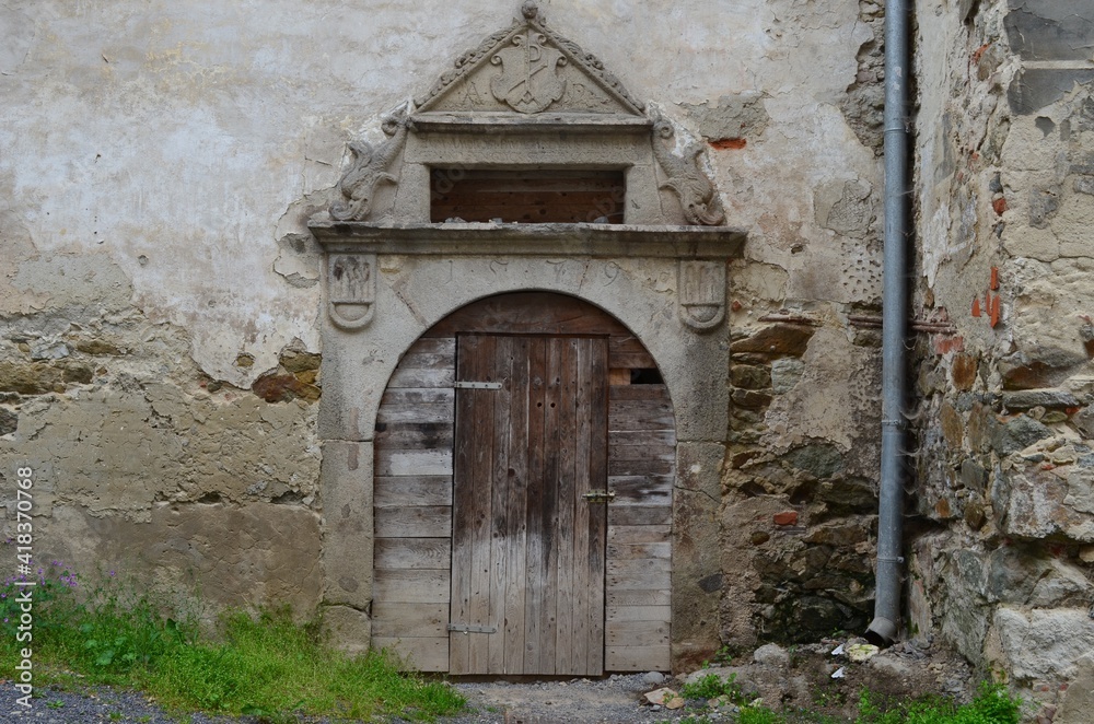 old wooden door in the wall with an arch, Banská Stiavnica, Slovakia,