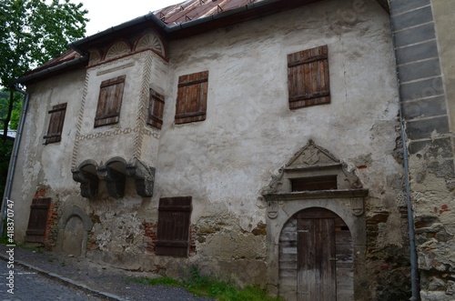 facade of an old house with a oriel window wooden shutters and door and a decorative arch, Banská Štiavnica