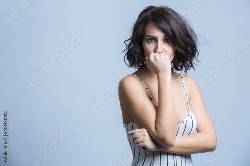 bella ragazza mora si deprime mettendo il pugno di fronte alla faccia , isolata su sfondo bianco photo