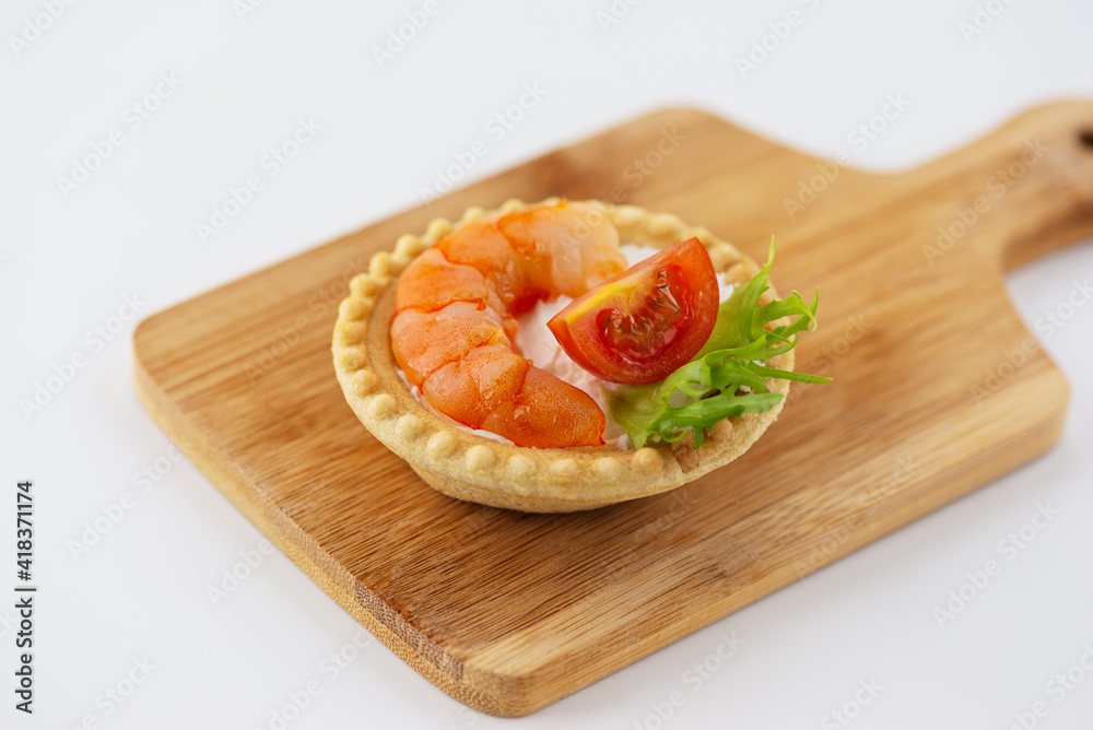 Tartlet with shrimp, tomato and cheese on a wooden board. Tartlet with shrimp, tomato and cheese on a wooden board.