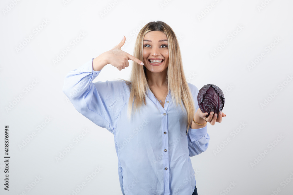 Pretty woman in blue outfit posing with single cabbage on white background Pretty woman in blue outfit posing with single cabbage on white background