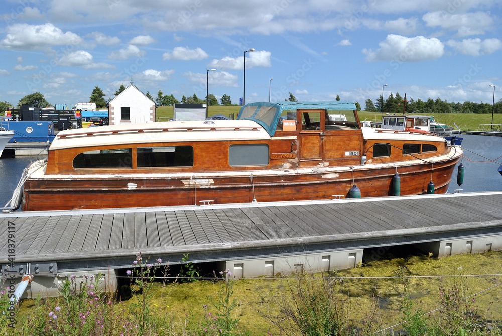 Traditional Cabin Cruiser Moored beside Pontoon on Sunny Canal Bank