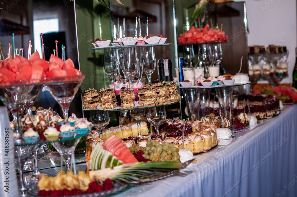 Sweet cakes at a wedding banquet. Catering, sweet festive buffet. Candy bar