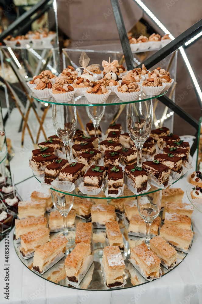 Sweet cakes at a wedding banquet. Catering, sweet festive buffet. Candy bar