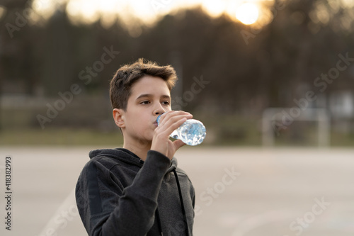 Young man drinks water during training.