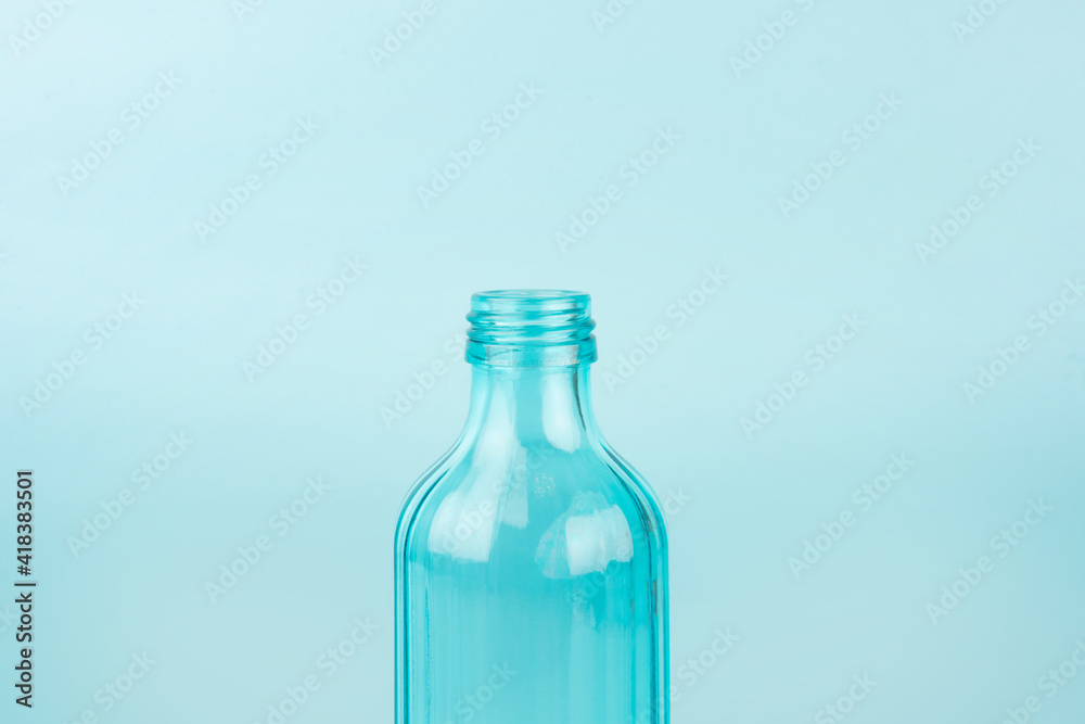 Blue glass bottle. Isolated on blue background. Concept of reusable containers Blue glass bottle. Isolated on blue background. Concept of reusable containers